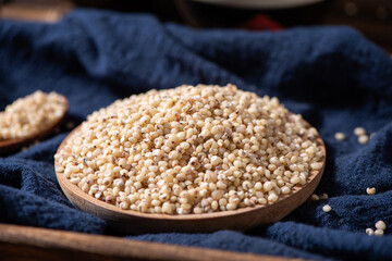 Sorghum seeds in plate on wooden table. Whole seeds of Sorghum Moench