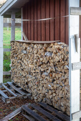 Wood for warming the house. Stack of logs to keep the house warm during cold weather. - 709526174