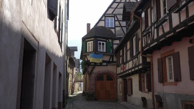 Ukranian flag hanging on half-timbered house in touristic historical town (Kaysersberg, France).