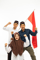 a beautiful islamic student standing clenched her arm while her friends standing behind her and one of them bring the indonesian flag