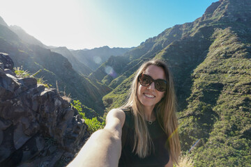 Naklejka premium Young woman in Morning Adventure Selfie Capturing the Serenity of a Mountainous Landscape