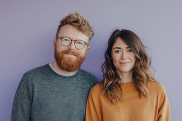 Portrait of a young couple standing together against a purple background. - obrazy, fototapety, plakaty