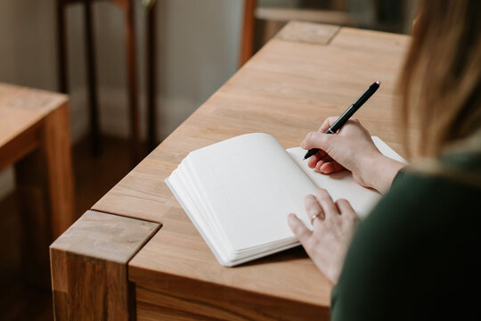 woman writing in blank journal for the new year