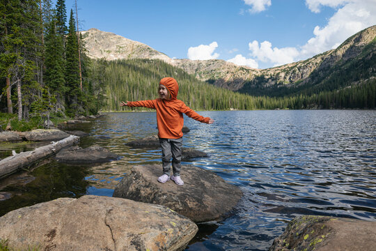Child exploring nature standing on a boulder by Timberline Lake