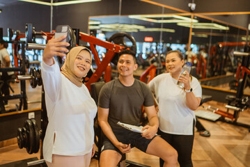 Fototapeta na wymiar gym trainer sitting and holding mockup phone with trainee
