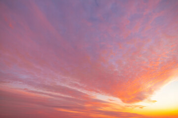 A beautiful sky tinted by the sun leaving vibrant shades of gold, pink, blue and multicolored. Clouds in the twilight evening and morning sky. Cloudy sky background in the evening and during the day.