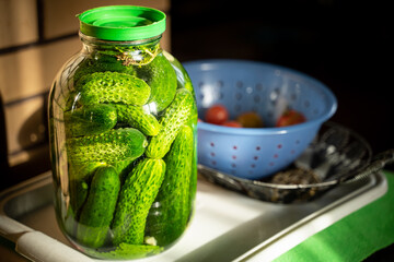 Fresh cucumbers in a jar are filled with brine, close-up. Preparing pickled cucumbers for the winter