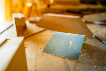 A piece of blue sandpaper on a table in a carpentry workshop - obrazy, fototapety, plakaty