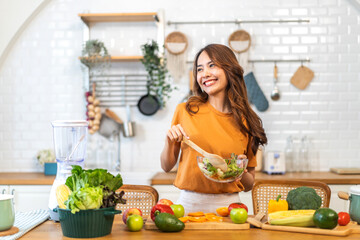 Portrait of beauty body slim healthy asian woman eating vegan food healthy with fresh vegetable salad in kitchen at home.diet, vegetarian, fruit, wellness, health, green food.Fitness and healthy food