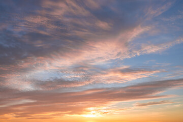 A beautiful sky tinted by the sun leaving vibrant shades of gold, pink, blue and multicolored. Clouds in the twilight evening and morning sky. Cloudy sky background in the evening and during the day.