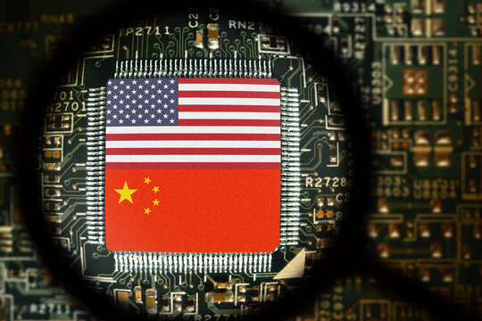 Flags of USA and China on a processor. Computer board with chip. View through magnifying glass. Artificial intelligence or AI