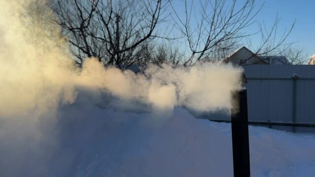 Smoke from the stove chimney in the cold winter.