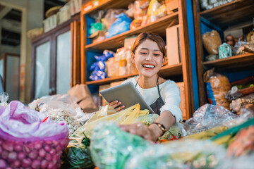 female green grocery seller checking products happily