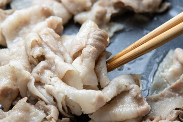 豚バラ肉(薄切り)をフライパンで炒める調理シーン。
