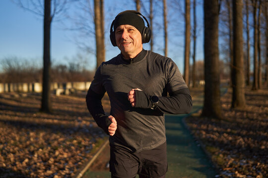 Mature man running in the park with headphones