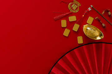 Chinese New Year  festival decorations, golden, flowers, paper fan, Chinese lanterns, envelopes on red background. Flat lay, top view, Text space images