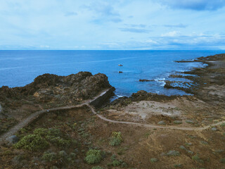 Atlantic Ocean and southern coast of Tenerife seen from the drone, trails of the Punta Rasca natural park. Horizon over water
