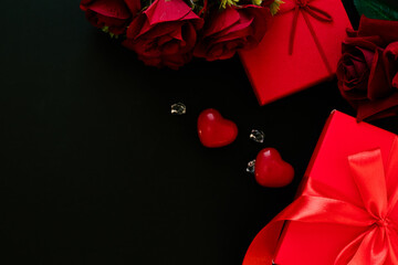 Valentine's Day decorations concept. Top view photo of gift boxes with rose and heart on black...