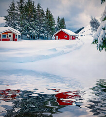 Red wooden houses under the fresh snow reflected in the calm waters of Kongsjordpollen fjord. Cold winter scene of Lofoten islands , Vestvagoy, Norway, Europe. Life over polar circle.