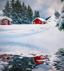 Fototapete Rund Red wooden houses under the fresh snow reflected in the calm waters of Kongsjordpollen fjord. Cold winter scene of Lofoten islands , Vestvagoy, Norway, Europe. Life over polar circle. © Andrew Mayovskyy
