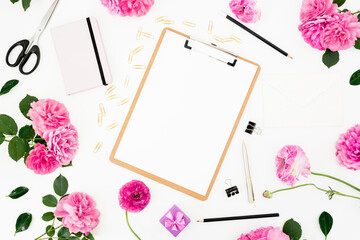 Background with clipboard, pastel flowers and accessories on white. Flat lay, top view. Freelancer...