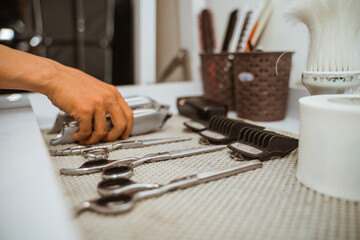 barber hand picking an shaver, haircut instrument from the table side view