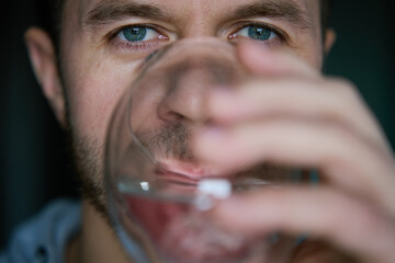 Man drinks water, Close-up shot of bearded man drinking fresh clean water from glass, Quenching...
