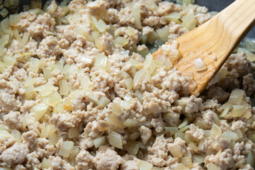 玉ねぎ(粗みじん切り)と鶏挽き肉をフライパンで炒める調理シーン。
