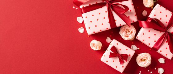 Valentines Day banner. Flat lay gift boxes, rose buds, petal on red background. Love, romance...