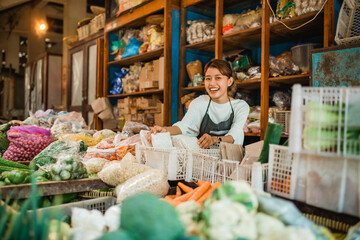 happy greengrocery seller working in traditional farmer market