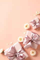 Valentines day background with gifts and flower buds on beige background. Flat lay, top view, vertical.