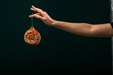 Donuts, bun, croissant Christmas toy on a black background. Creative collage.