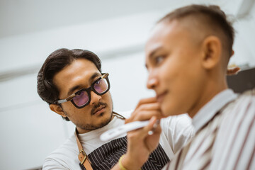 close up photo of professional asian hairdresser focused on doing hair trimming