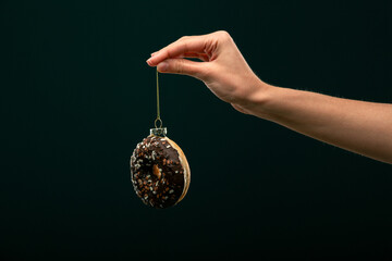 Donuts, bun, croissant Christmas toy on a black background. Creative collage.