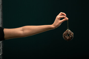 Donuts, bun, croissant Christmas toy on a black background. Creative collage.