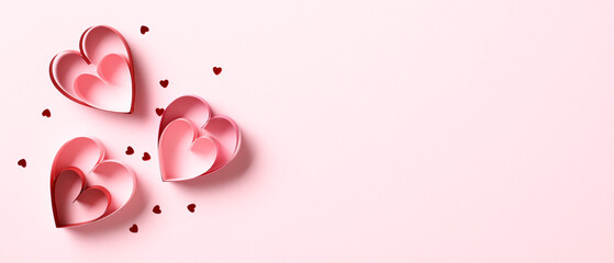Fototapeta premium Valentines Day banner with red paper hearts and confetti on pink background. Top view with copy space.