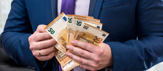 businessman in suit hold EU euro paper money