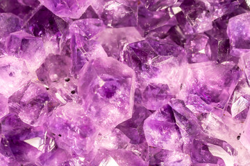 Amethyst purple crystals. Gems. Mineral crystals in the natural environment. Texture of precious and semiprecious stones. Seamless background with copy space colored shiny surface of precious stones.