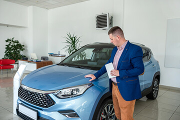 Smiling businessman choosing best modern car at showroom