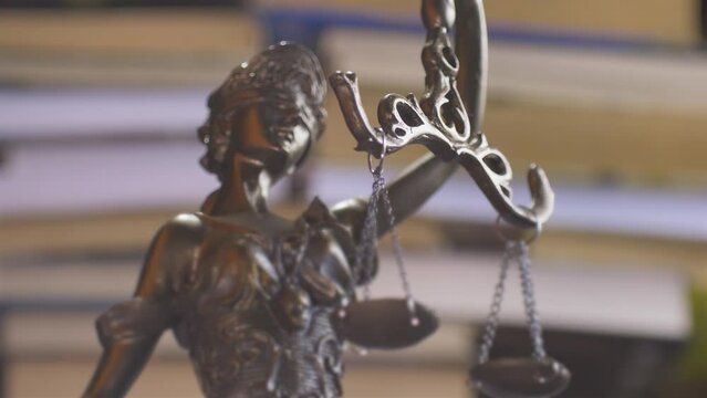 Statue of themis or lady justice. Femida on books background in liberty. Lawyer, law library concept
