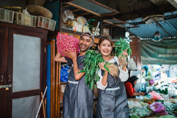 happy couple working together as vegetable seller at farmer market