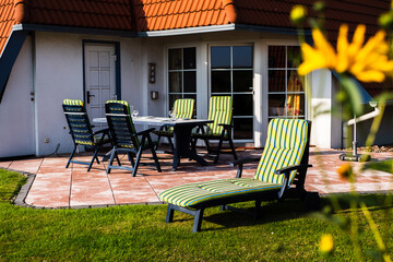 Liege und Stühle vor einem Ferienhaus