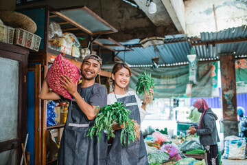 potrait happy couple working together as vegetable seller at farmer market