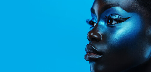Beautiful African face on bright blue wall background, Concept of beauty, makeup, cosmetics..