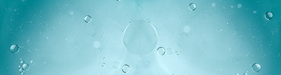 Oil and water, transparent blue bubbles, soap suds with water blue background. Space for copy.