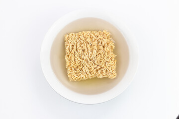 Instant noodle in white plate on white background, top view.