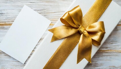blank gift card with golden bow on white top view