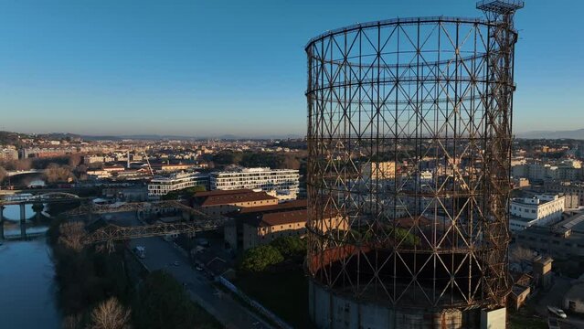 Alba sul Gazometro del quartiere post industriale Ostiense a Roma, Italia.
Veduta aerea con drone dei raggi del sole che passano attraverso la vecchia struttura del Gasometro.
