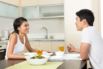 Happy Asian couple eating at home