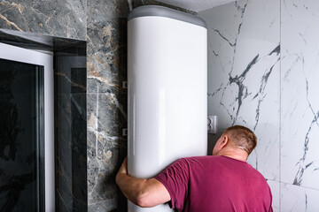 Man installing electric water heater in bathroom.